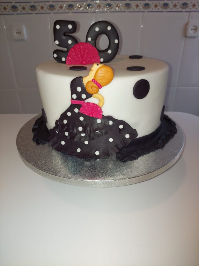 Tarta de cumpleaños elegante en negro para 50 años con detalles dorados y rojos