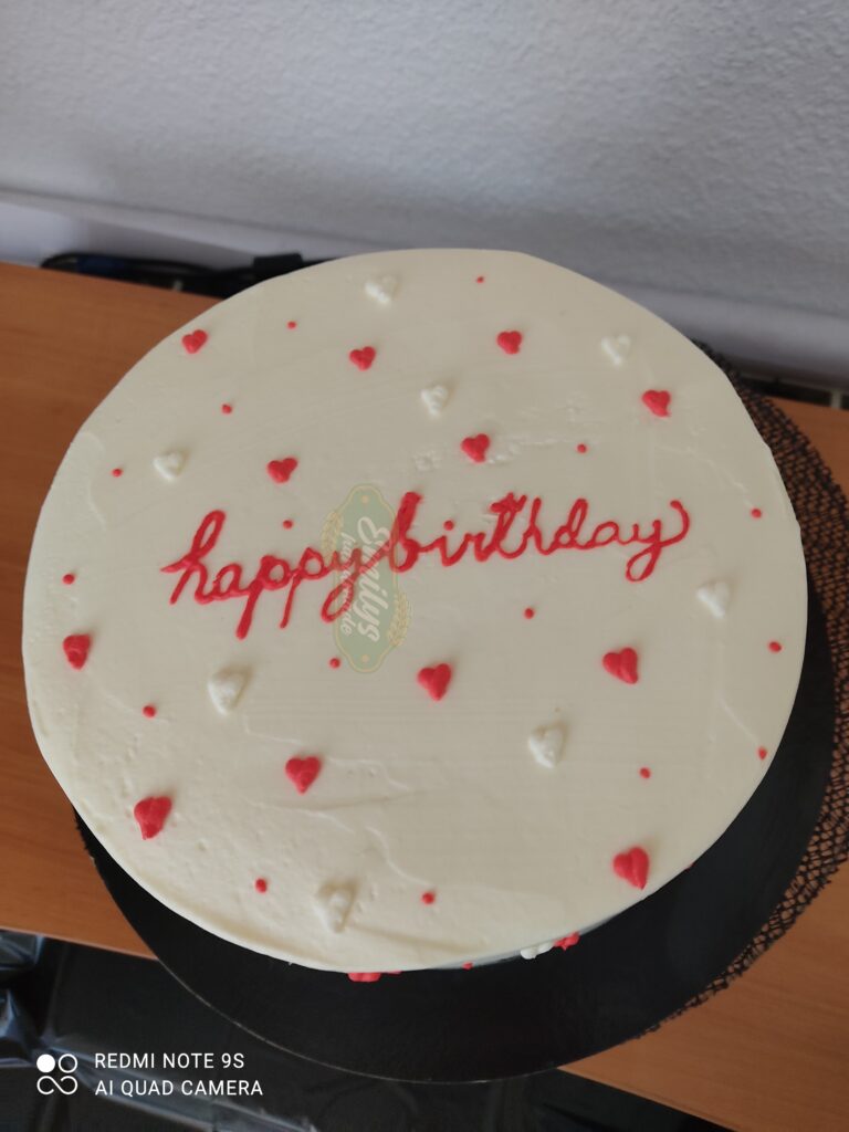 Tarta minimalista blanca decorada con pequeños corazones rojos