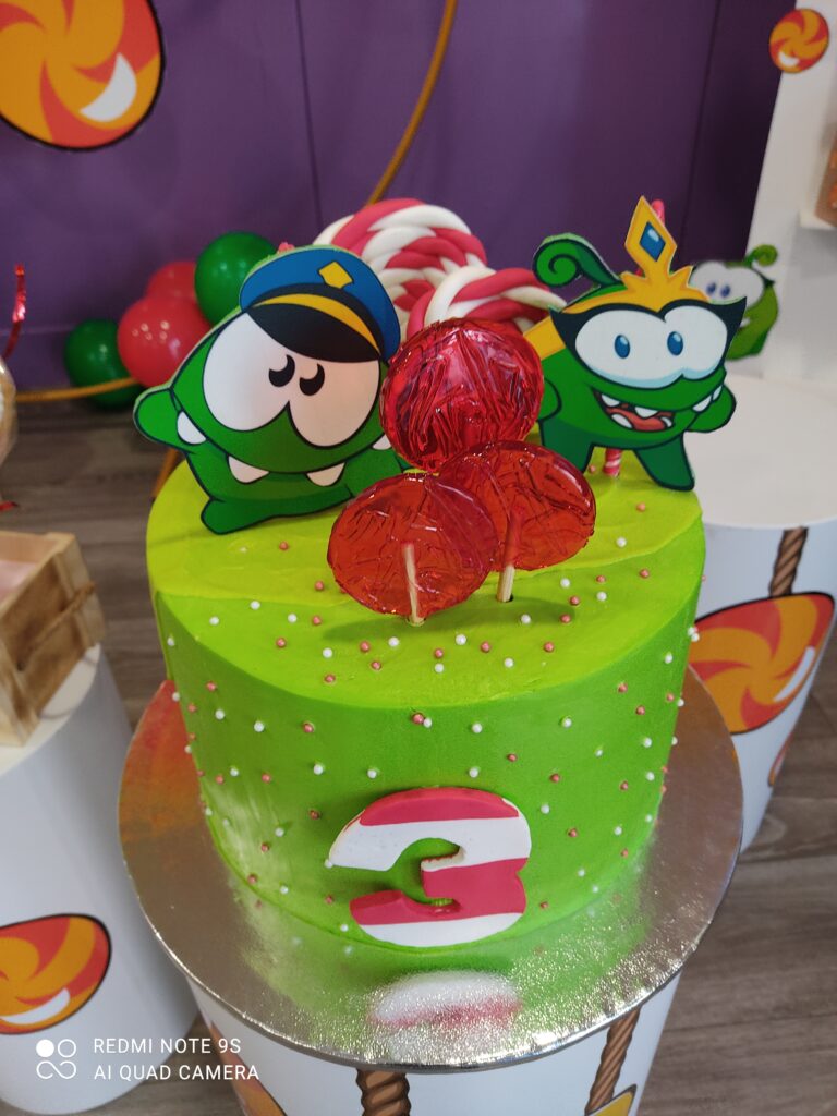 Tarta de cumpleaños infantil personalizada con temática de dibujos animados en crema verde y decoraciones de fondant en Madrid