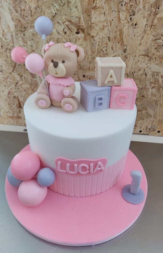 Tartas personalizadas en Madrid – diseño artesanal infantil rosa de cumpleaños para niña con osito y cubos decorativos, diseño tierno y personalizado